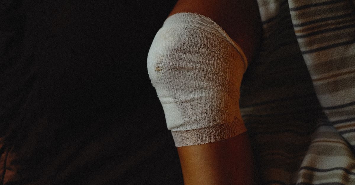A detailed view of a bandaged knee indicating injury care and healing process.