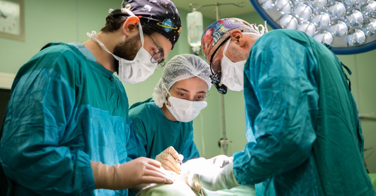 A focused surgical team operating in a brightly lit hospital room, showcasing teamwork and precision.