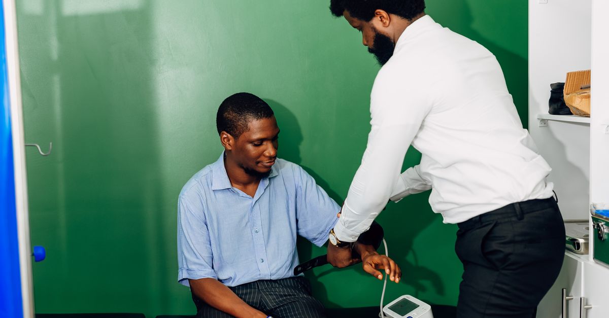 A doctor performs a blood pressure check in a Lagos clinic, emphasizing healthcare.